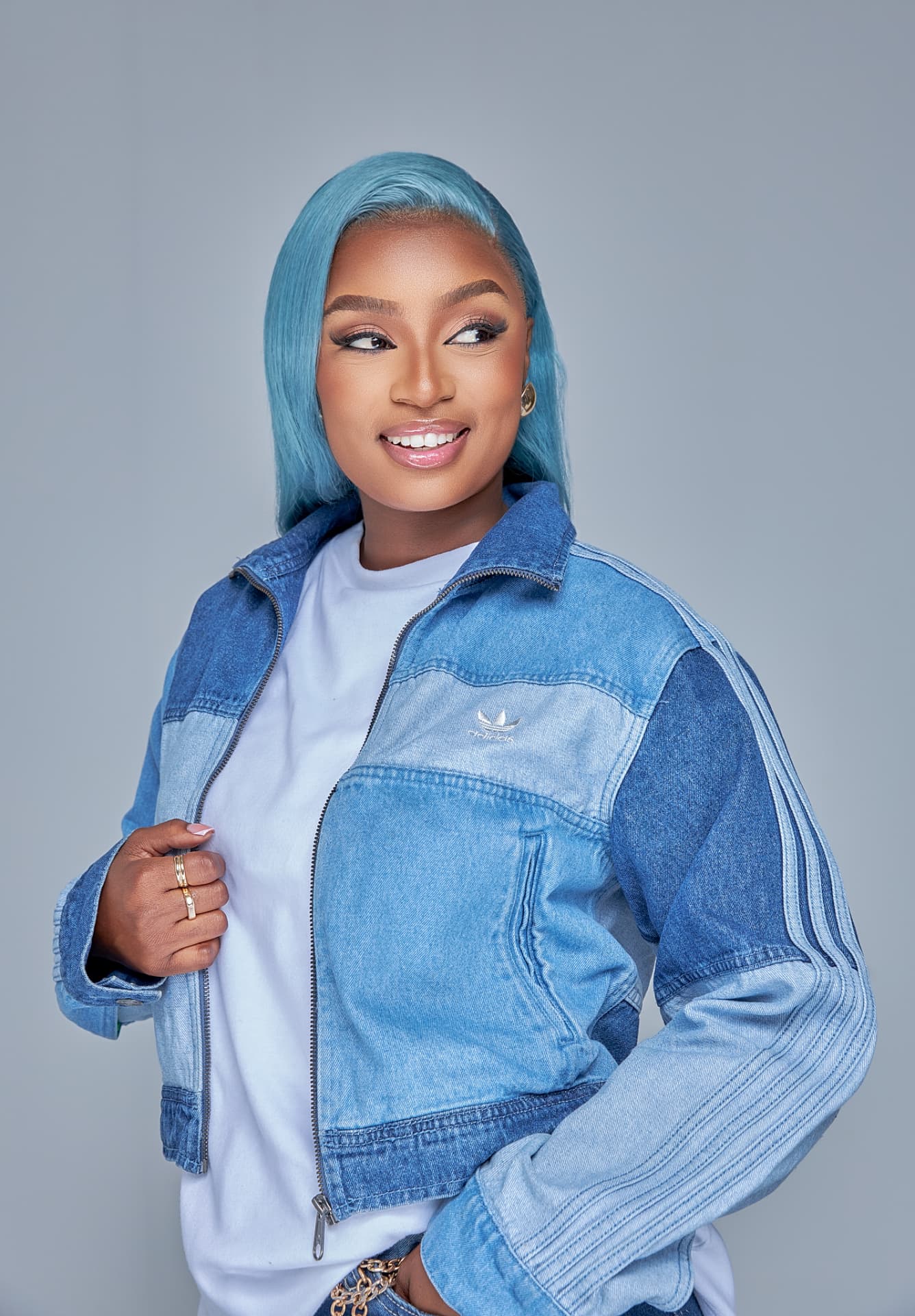 Musa Yende in a denim jacket with blue hair